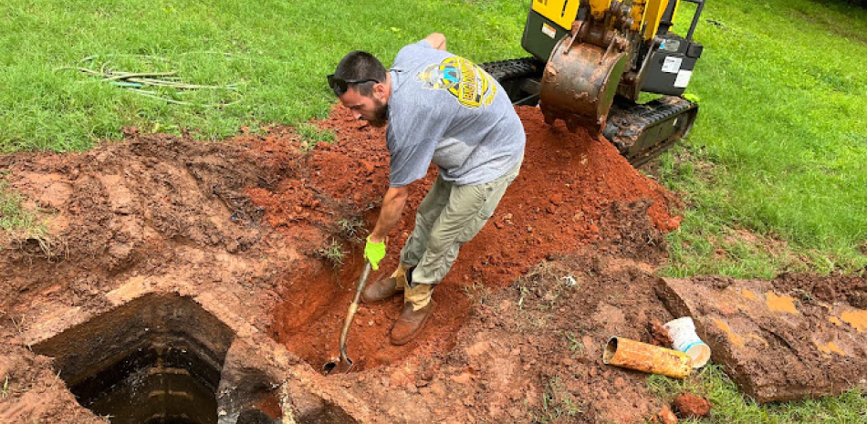 worker excaving in a backyard to install a septic