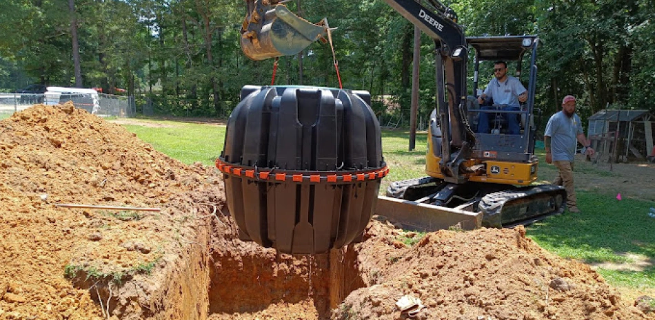 workers replacing the septic tank of a house on a yard