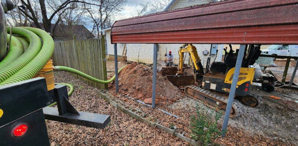 yellow construction machine excaving on a space on a backyard